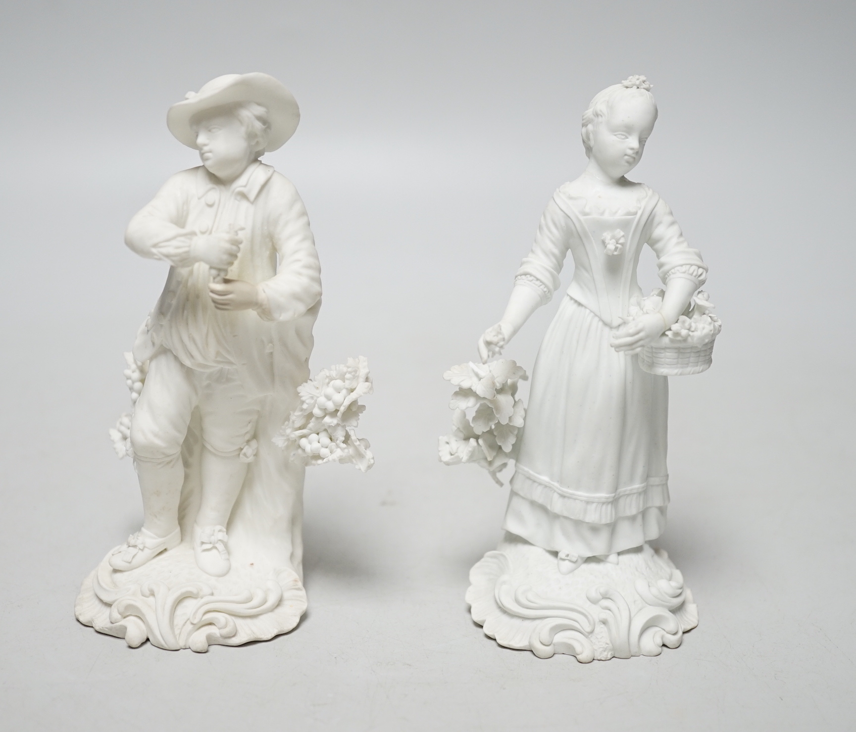 A pair of 18th century Derby biscuit figures of a man and woman, he with a bunch of grapes and she with a basket of flowers possibly representing Spring and Autumn, pattern number 125